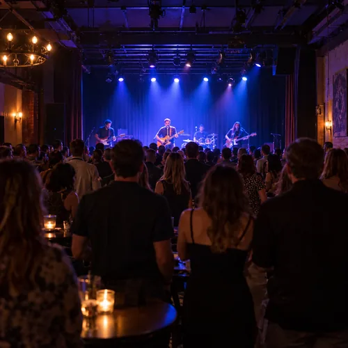 Audience at a small local concert under blue stage lighting