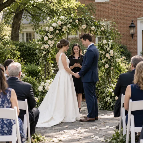 A small garden wedding ceremony with an ivory floral arch at a local brick venue